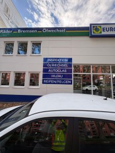 Fertig montierte Werbeschilder an der Euromaster-Fassade in Köln