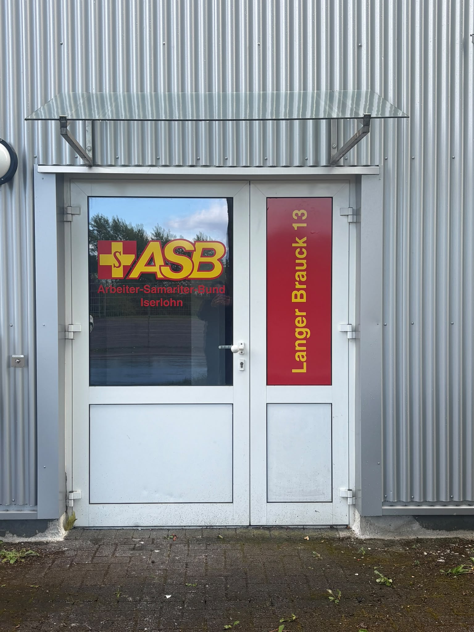 WhatsApp Image 2026-09-09 at 15.27.48 Eingangstür des ASB Iserlohn mit Logo und Adressbeschriftung Langer Brauck 13.