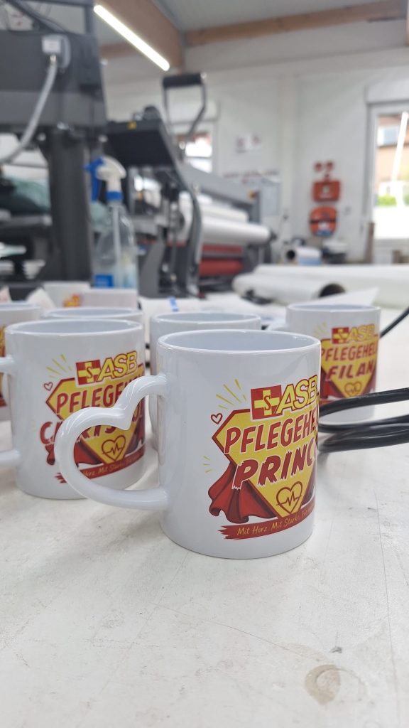 ASB-Tasse mit Pflegeheldin-Motiv in Rot und Gelb und persönlichem Vornamen.